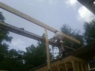Carpenter setting a ridge beam over a new addition frame — Ice Dam Removal by Roofing Brothers in Cedarpines Park