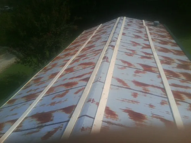 Rusted metal roof panels with new wood purlins before replacement — Storm Damage Roof Repair in Cedarpines Park by Roofing Brothers