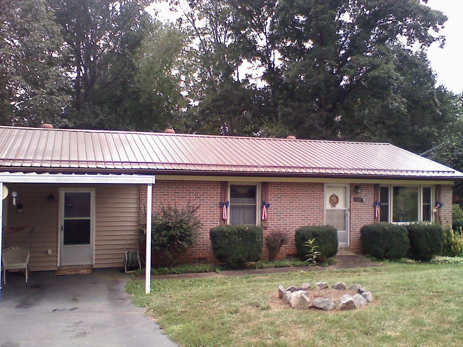 Bronze metal roof and carport on a brick ranch home — Roof Repair work by our crew in Cedarpines Park